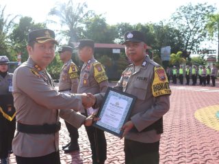 Bhabinkamtibmas Polsek Buru, Bripka Buzari mendapatkan penghargaan dari Kapolres Karimun, AKBP Ryky W. Muharam.