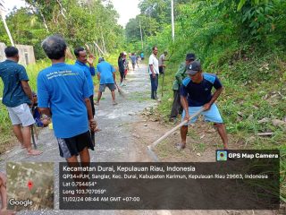 Babinsa melakukan gotong-royong bersama warga membersihkan jalan di desa demi menciptakan kepedulian terhadap lingkungan.