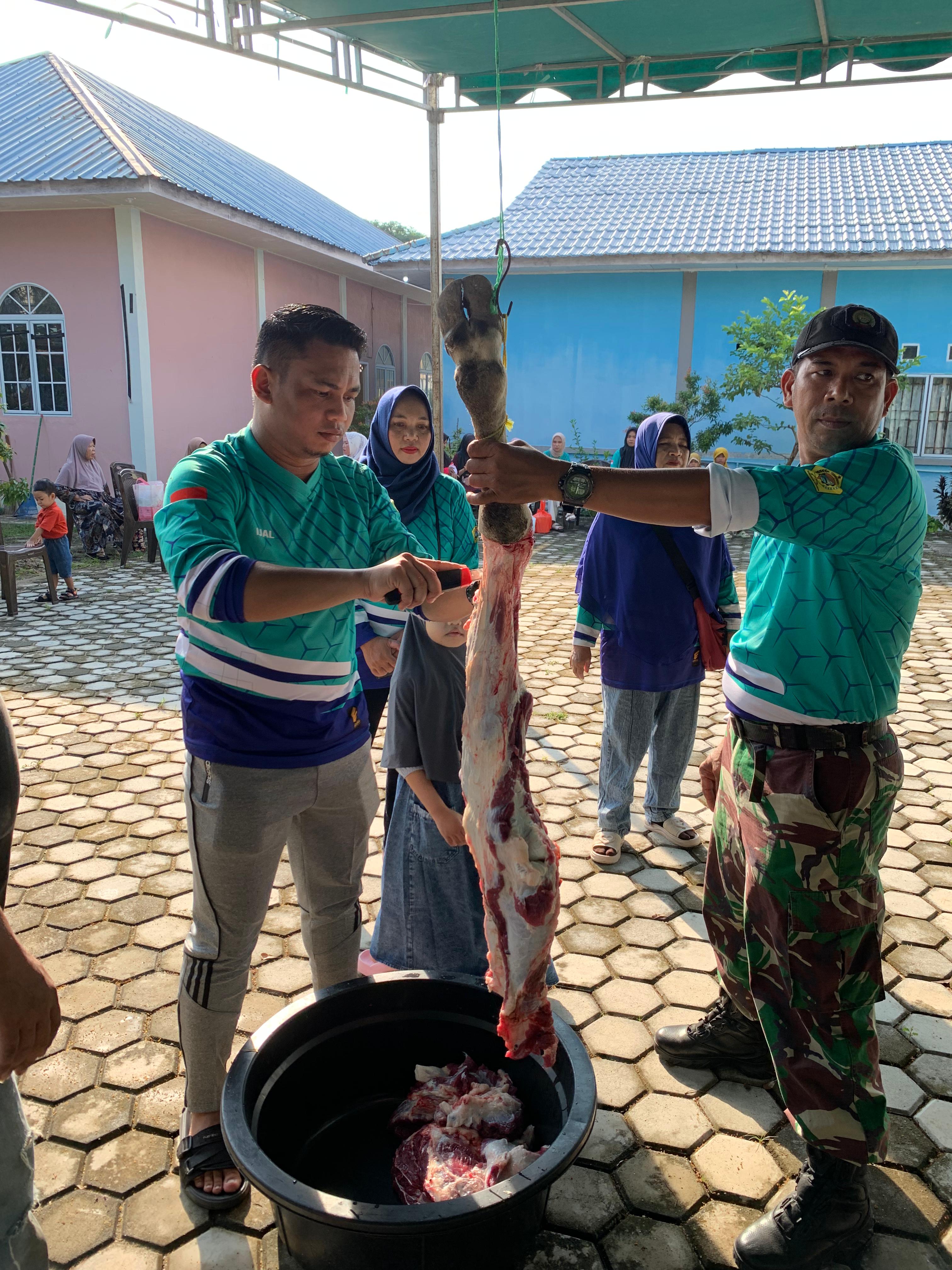 Babinsa Kelurahan Sungai Lakam Timur Koramil 01/Balai, Serda Rinto membantu kegiatan penyembelihan hewan qurban, Selasa (18/06/2024).