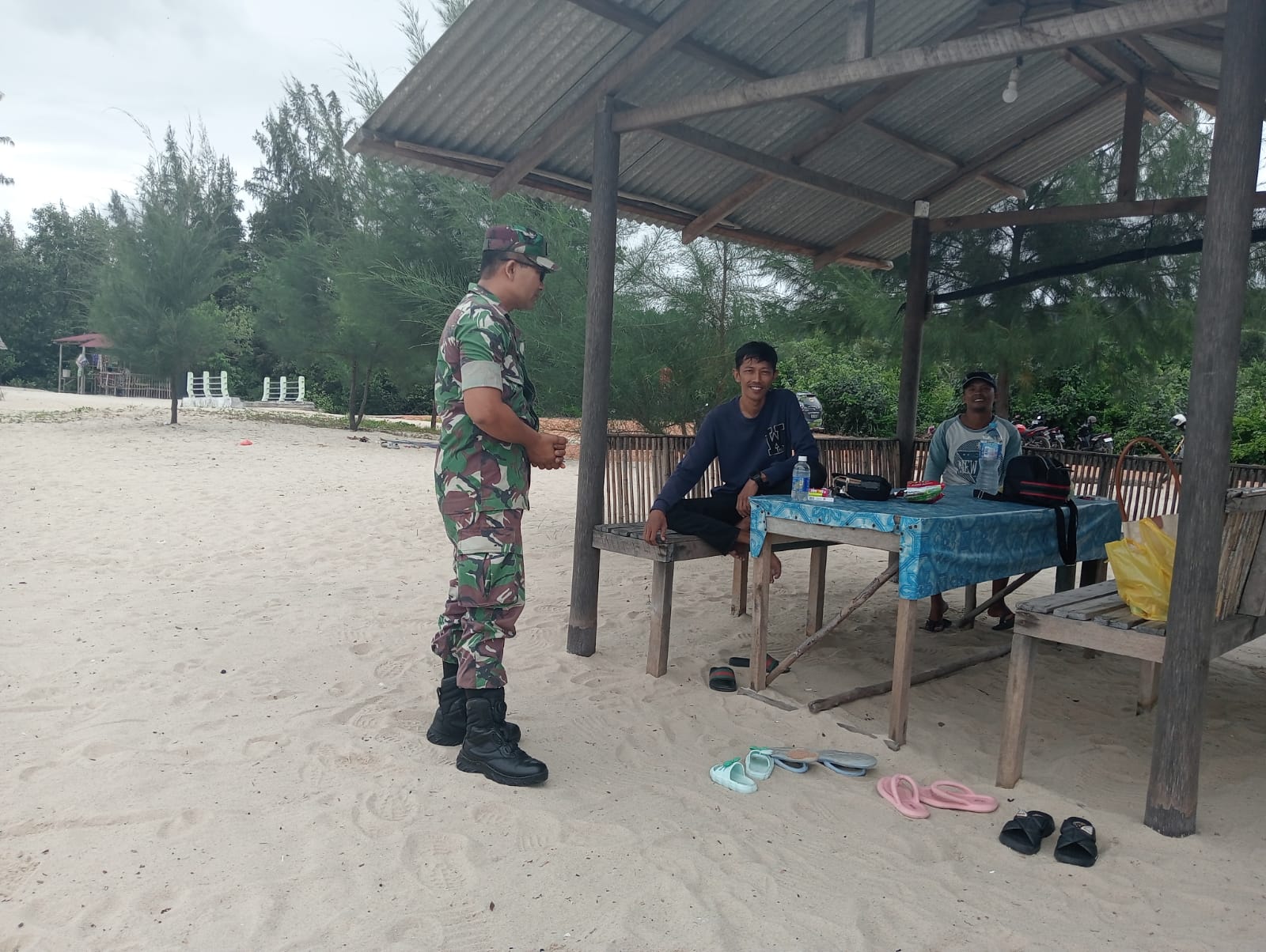 Babinsa Desa Pongkar Koramil 04/Tebing, Serda Efin Wijaya melaksanakan Komsos dengan para pengunjung wisata Pantai Ketam di Desa Pongkar.