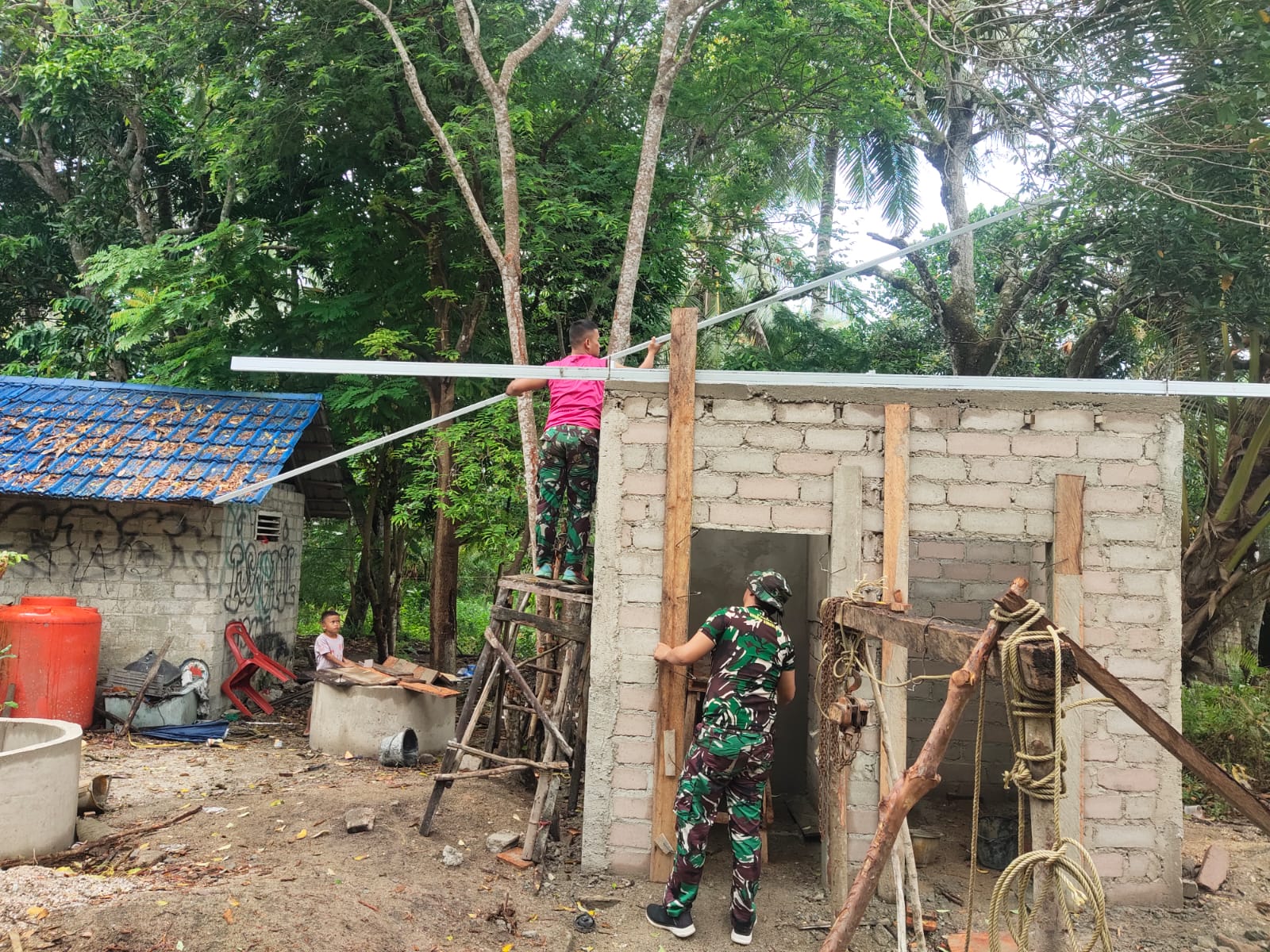 Anggota Satgas TMMD ke-121 Kodim 0317/TBK memulai pemasangan atap baja ringan di MCK Dusun Tebing, Jumat (9/8/2024).