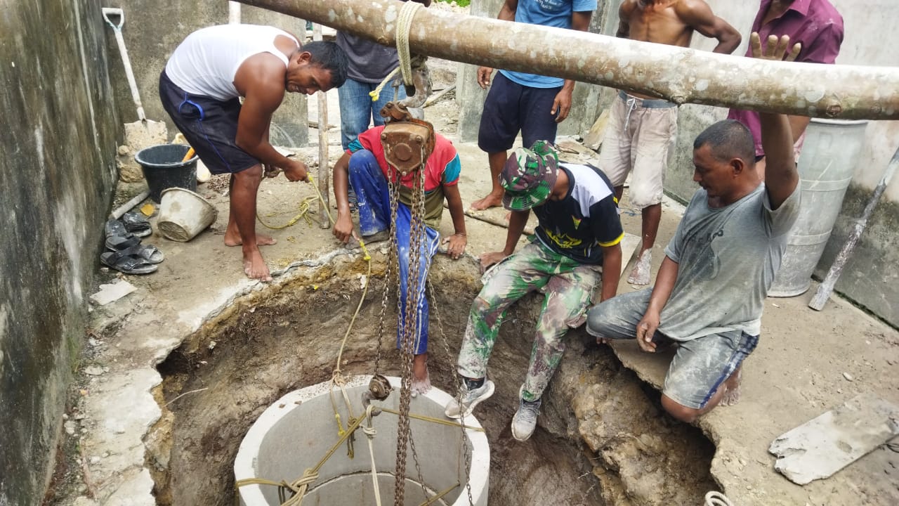 Anggota Satgas TMMD ke-121 Kodim 0317/TBK bahu membahu melakukan pemasanagan cincin sumur gali di Dusun Tanjung Perai.