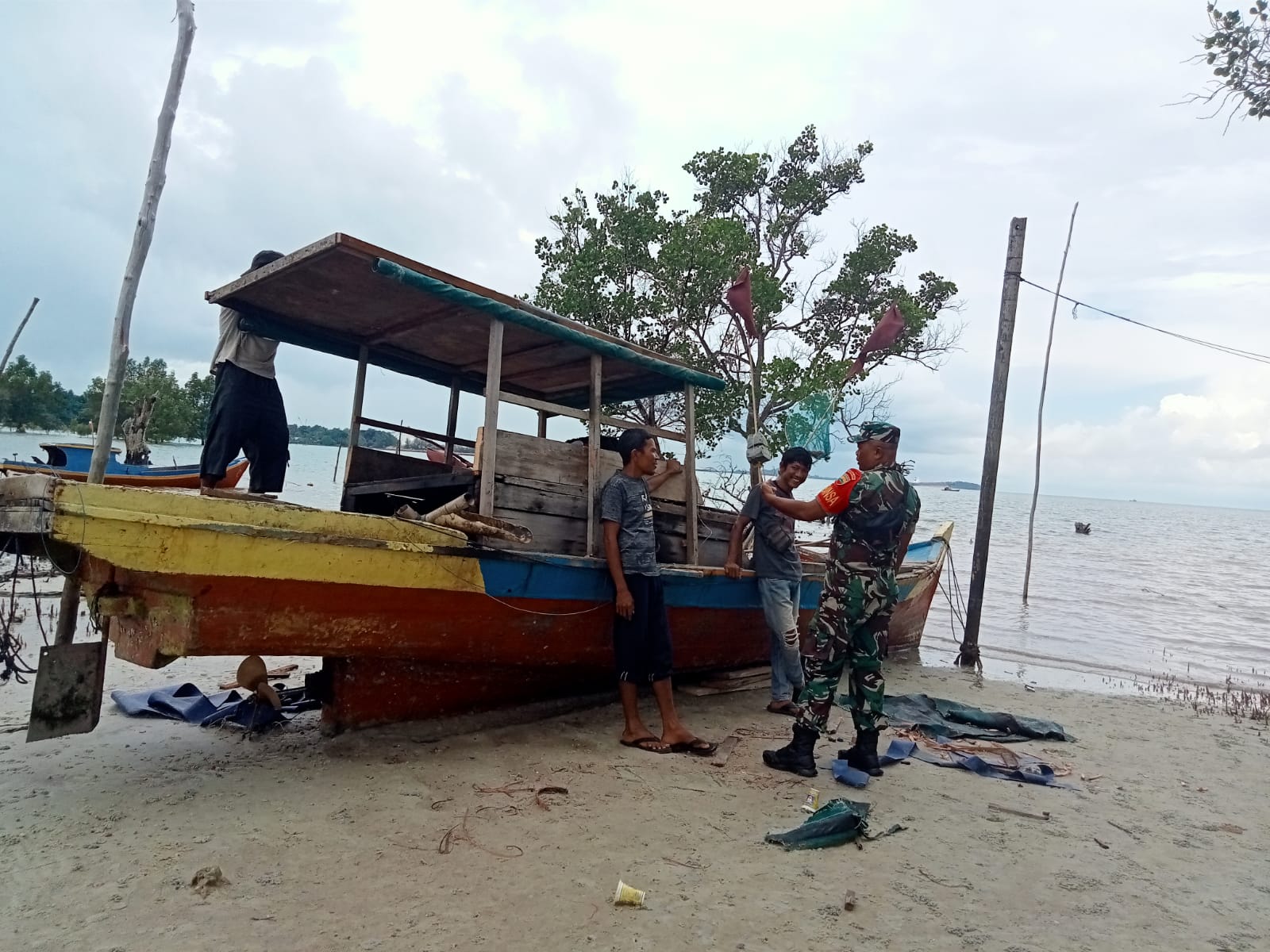 Sertu Atmaja, Babinsa Desa Pangke dari Koramil 04/Tebing, melaksanakan komsos dengan Saiful, seorang nelayan di Pantai Indah Pangke.