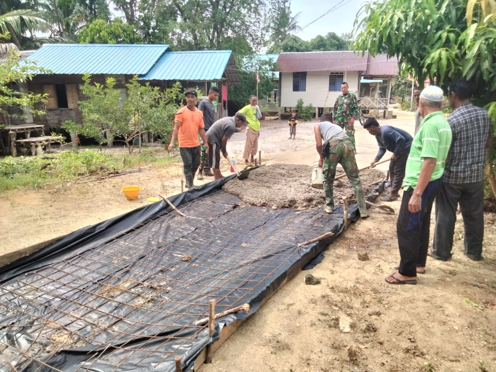 Letda Inf Erikson Nababan mengecek progres pengerjaan semenisasi Jalan di Desa Sanglar, Kecamatan Moro, Kabupaten Karimun, Sabtu (10/8/2024).