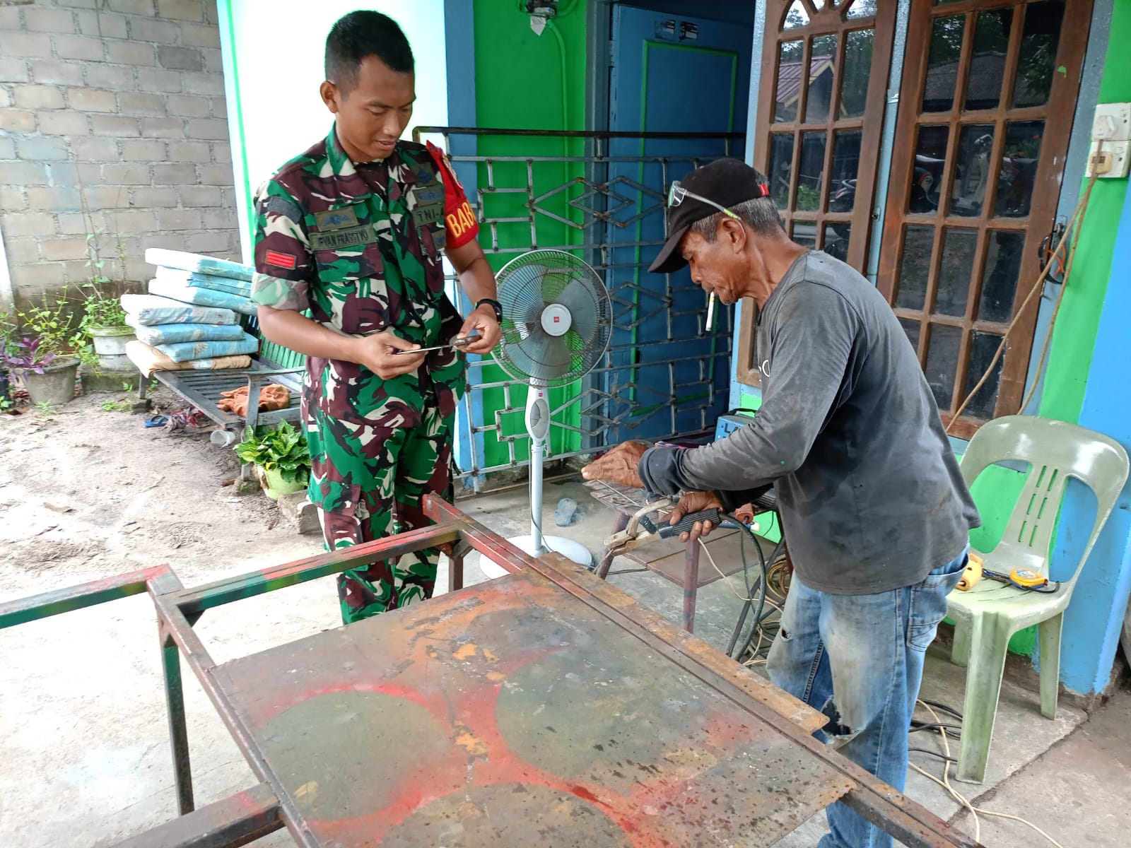 Praka Irvan dari Babinsa Kelurahan Moro, Koramil 02/Moro, melaksanakan kegiatan komsos dengan Ghani, seorang teknisi las berusia 54 tahun.